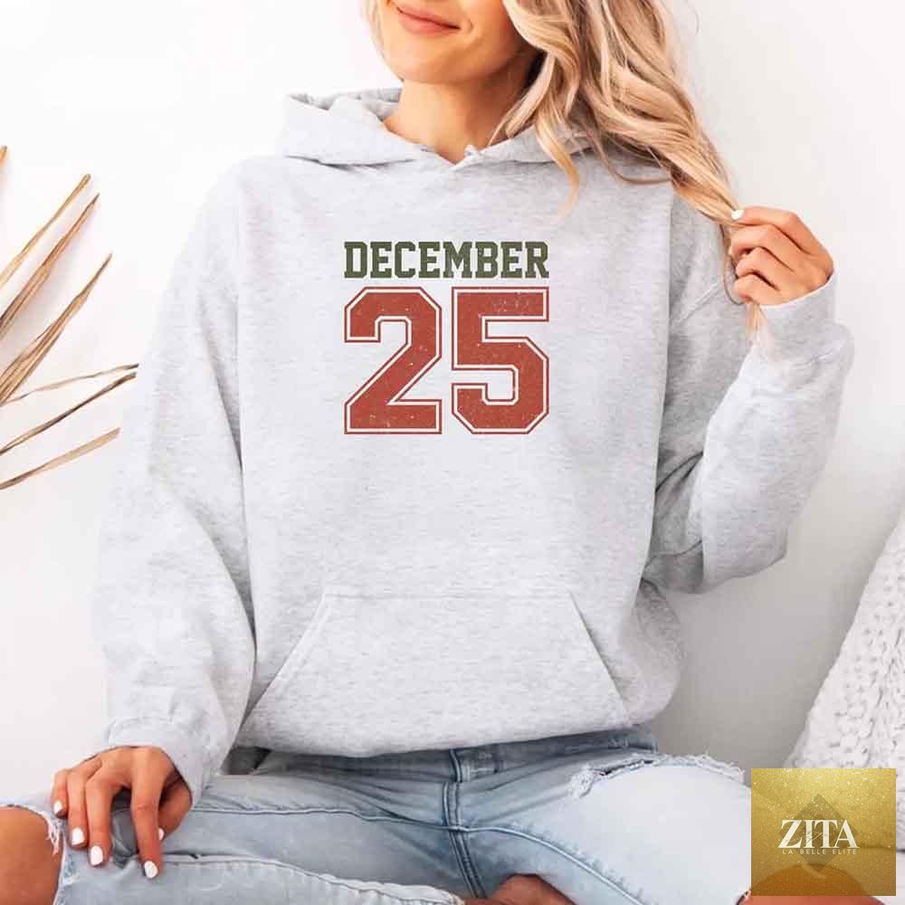 Red retro Christmas hoodie by Adorb Custom Tees featuring festive December 25 holiday design and cozy holiday wear style.