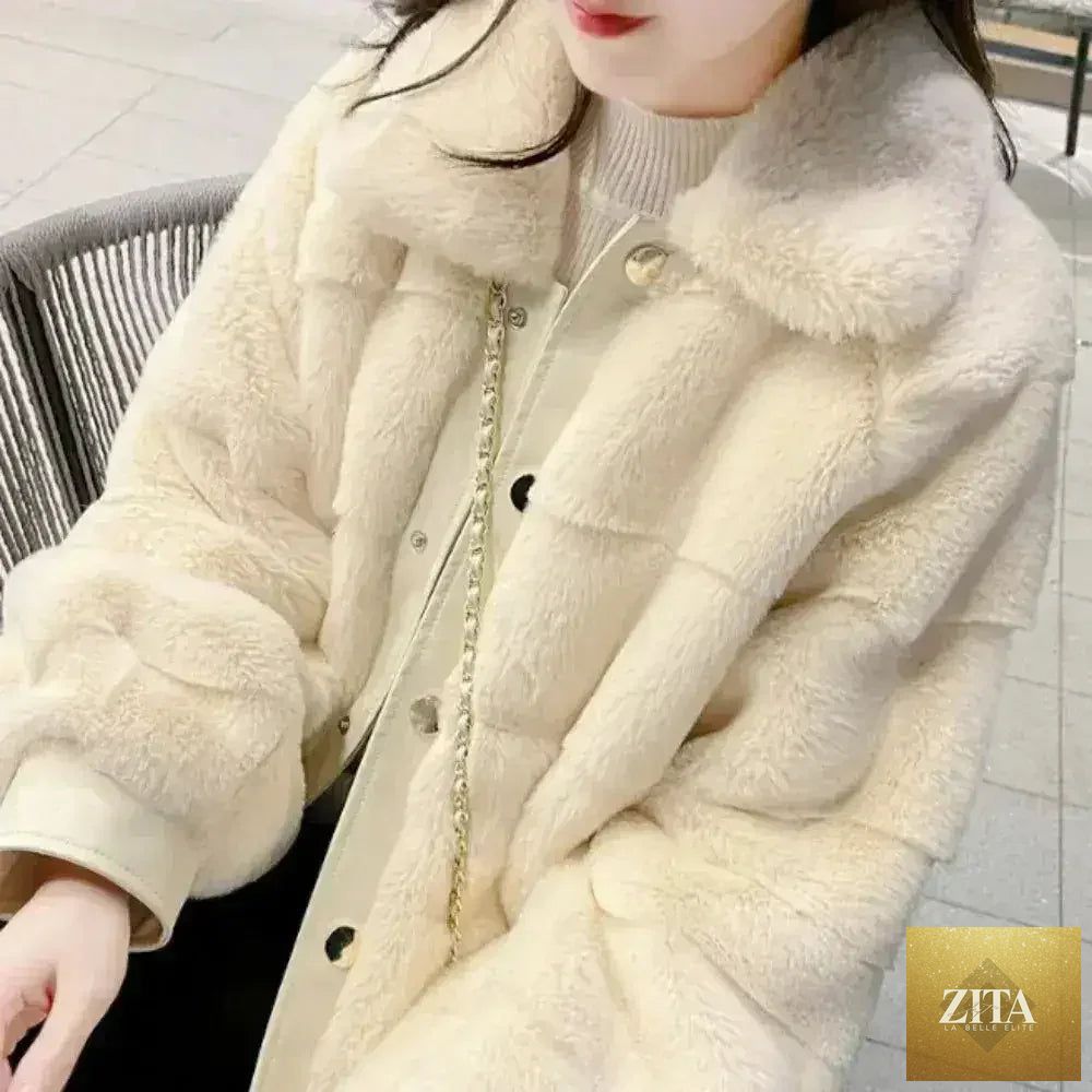 White faux fur jacket with vegan leather trimmed cuffs from Zita La Belle Elite, shown on a hanger with a plush background.