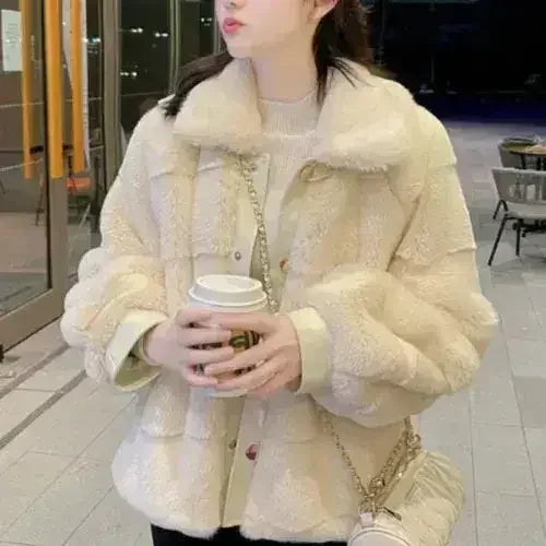White faux fur jacket with vegan leather trimmed cuffs from Femstylo, shown on a hanger with a cozy, plush appearance.