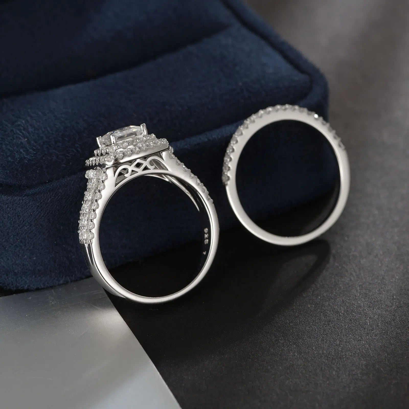 Elegant women's wedding ring set featuring moissanite stones, sterling silver halo design, and princess cut accents.
