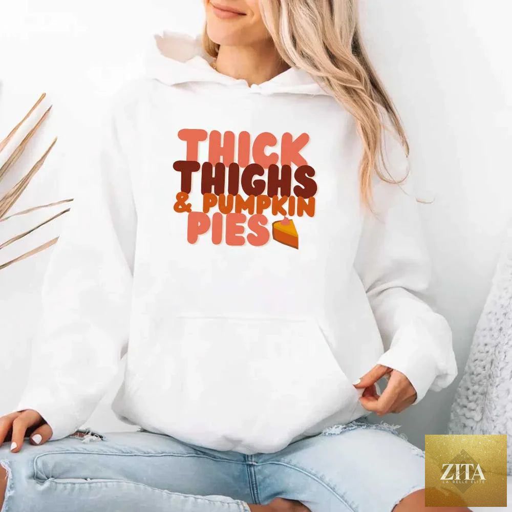 White fleece hoodie with "Thick Thighs and Pumpkin Pies Fall Vibes" graphic, casual style, worn by model.