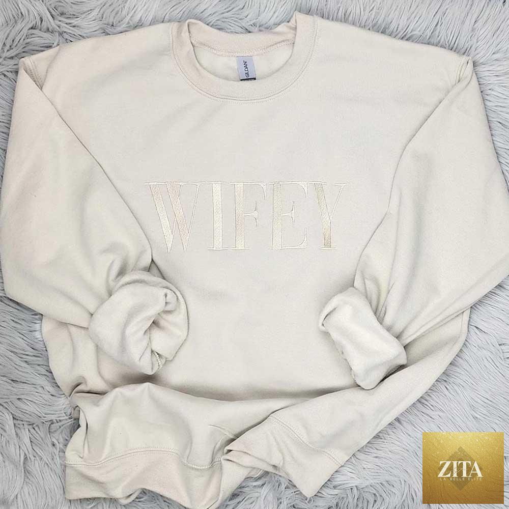 Embroidered “Wifey” sweatshirt by Adorb Custom Tees in champagne sand, cozy crewneck with stylish Wifey design.