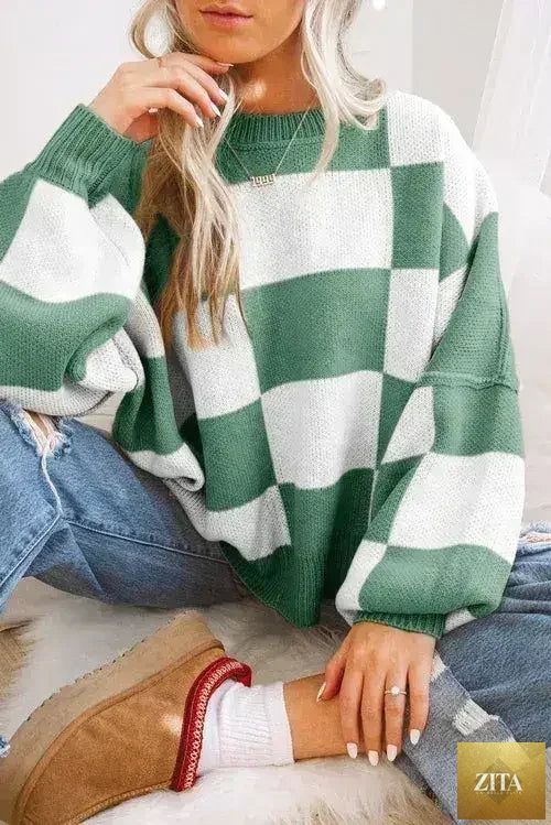 Orange checkered Femstylo sweater with bishop sleeves, featuring a cozy knit design and stylish pattern.