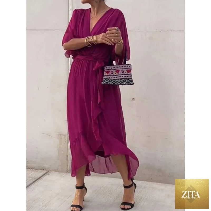 FitiqueFit batwing sleeve v-neck midi dress with tied irregular hem, flowing fairy dress style, shown on a model.