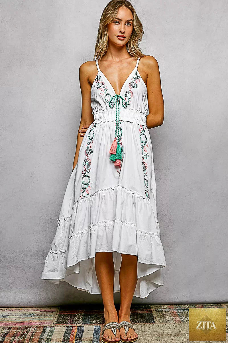 Blu Lotus Boutique embroidered detail tassel tie smocked waist midi tiered cami dress with shoulder straps and floral embroidery.