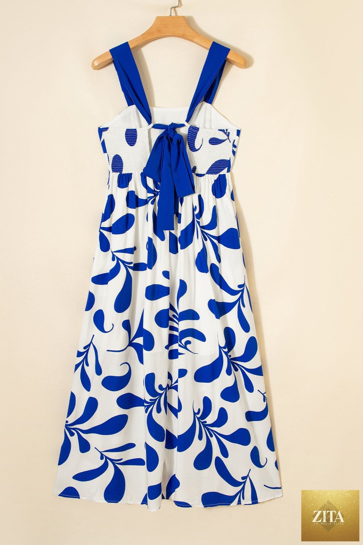 Blue floral print maxi dress with crisscross tie back and sleeveless design by Wild and Free Boutique.