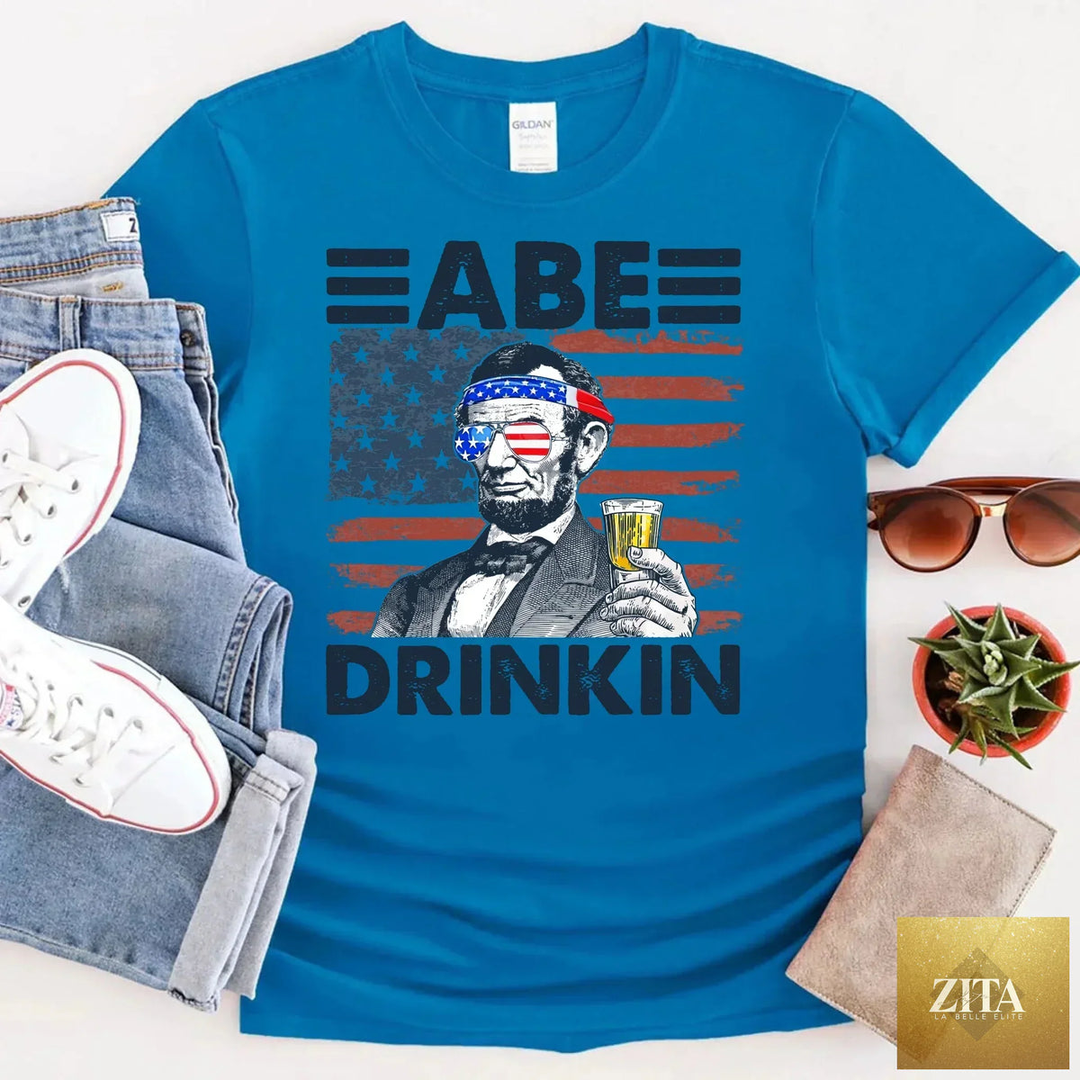 A patriotic Abraham Lincoln T-shirt from Adorb Custom Tees featuring a Fourth of July design with Lincoln and patriotic elements.