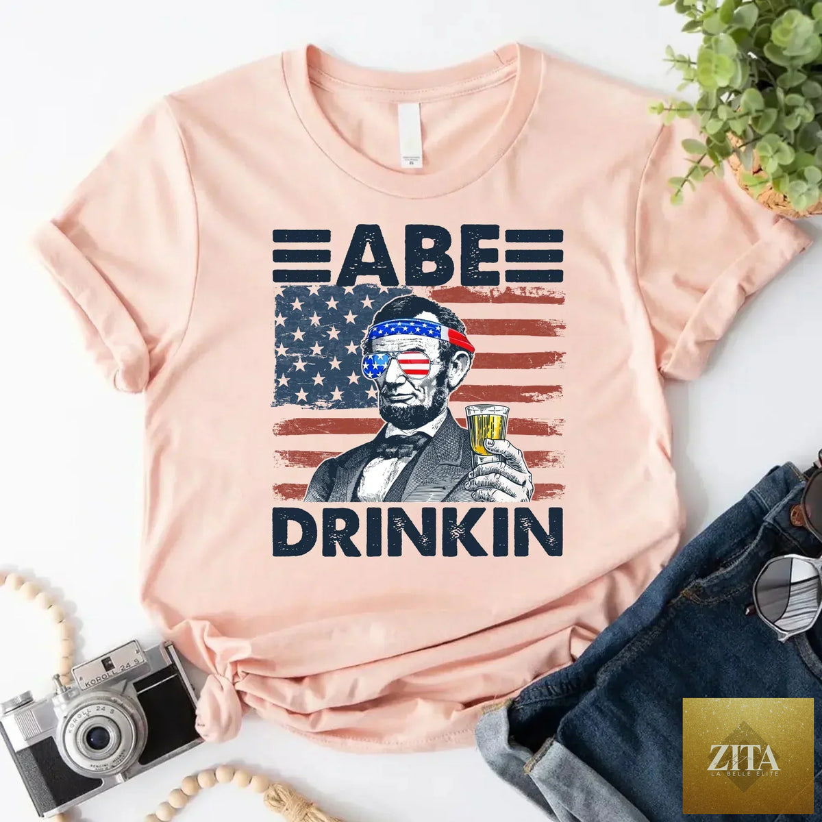 Red and white Abraham Lincoln patriotic T-shirt featuring a fun drinking design for 4th of July celebrations, by Adorb Custom Tees.