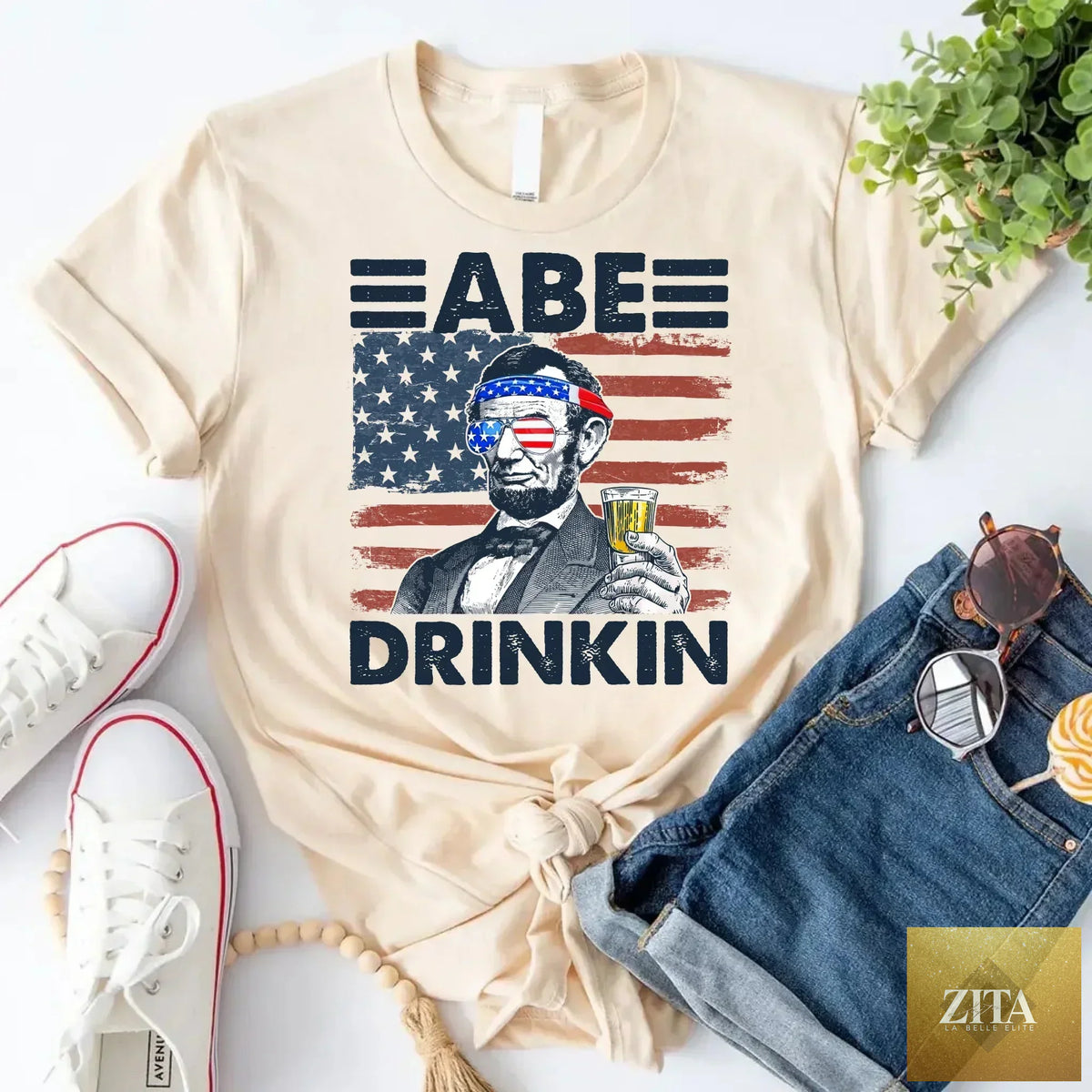 A patriotic Abraham Lincoln T-shirt from Adorb Custom Tees featuring a 4th of July design with Lincoln and patriotic elements.