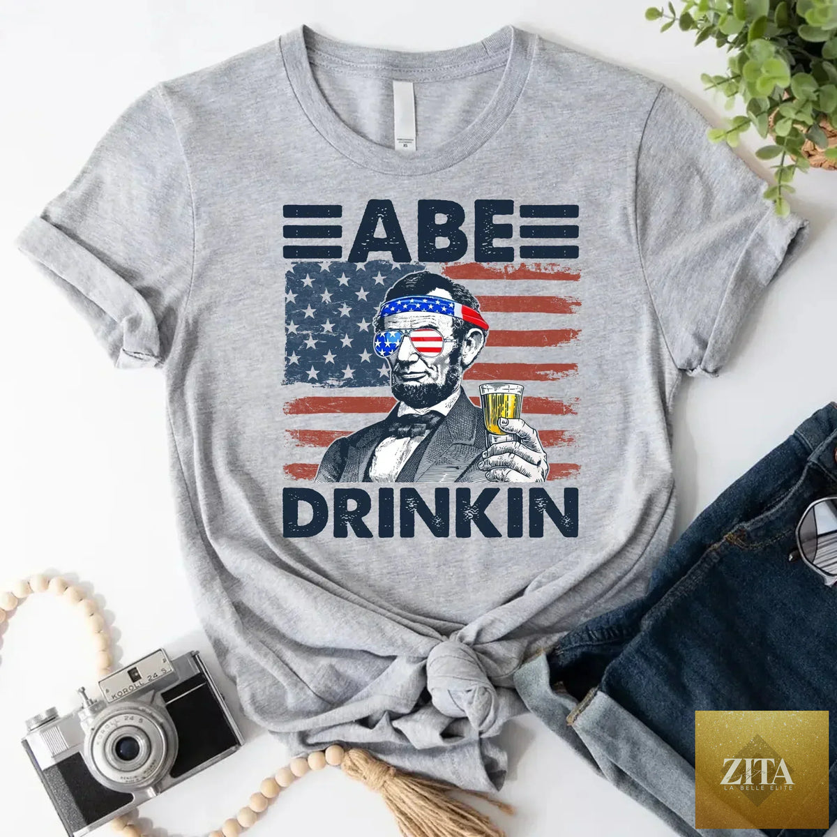 Natural, patriotic Abe Drinkin 4th of July T-Shirt from Adorb Custom Tees featuring Abraham Lincoln in a festive drinking design.