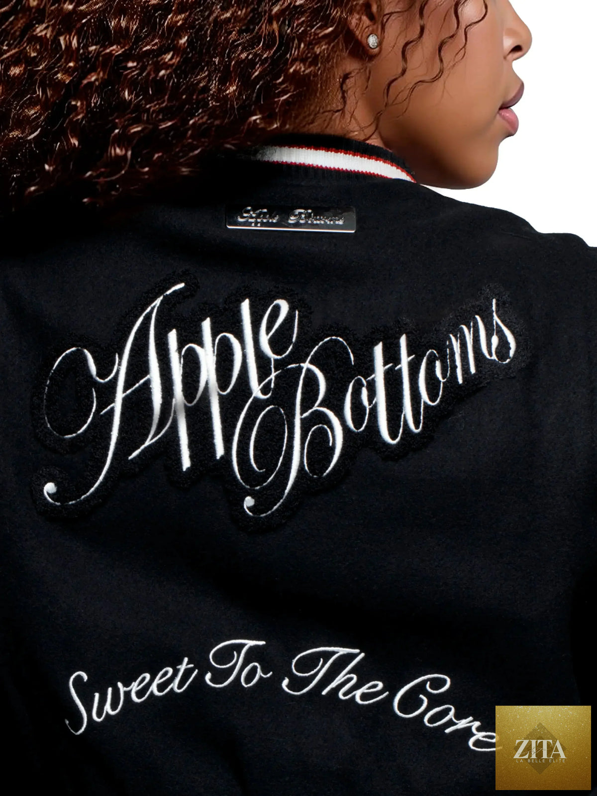Apple Bottom Jeans varsity jacket in black with white sleeves, front button closure, and Apple Bottom Jeans logo on the chest.