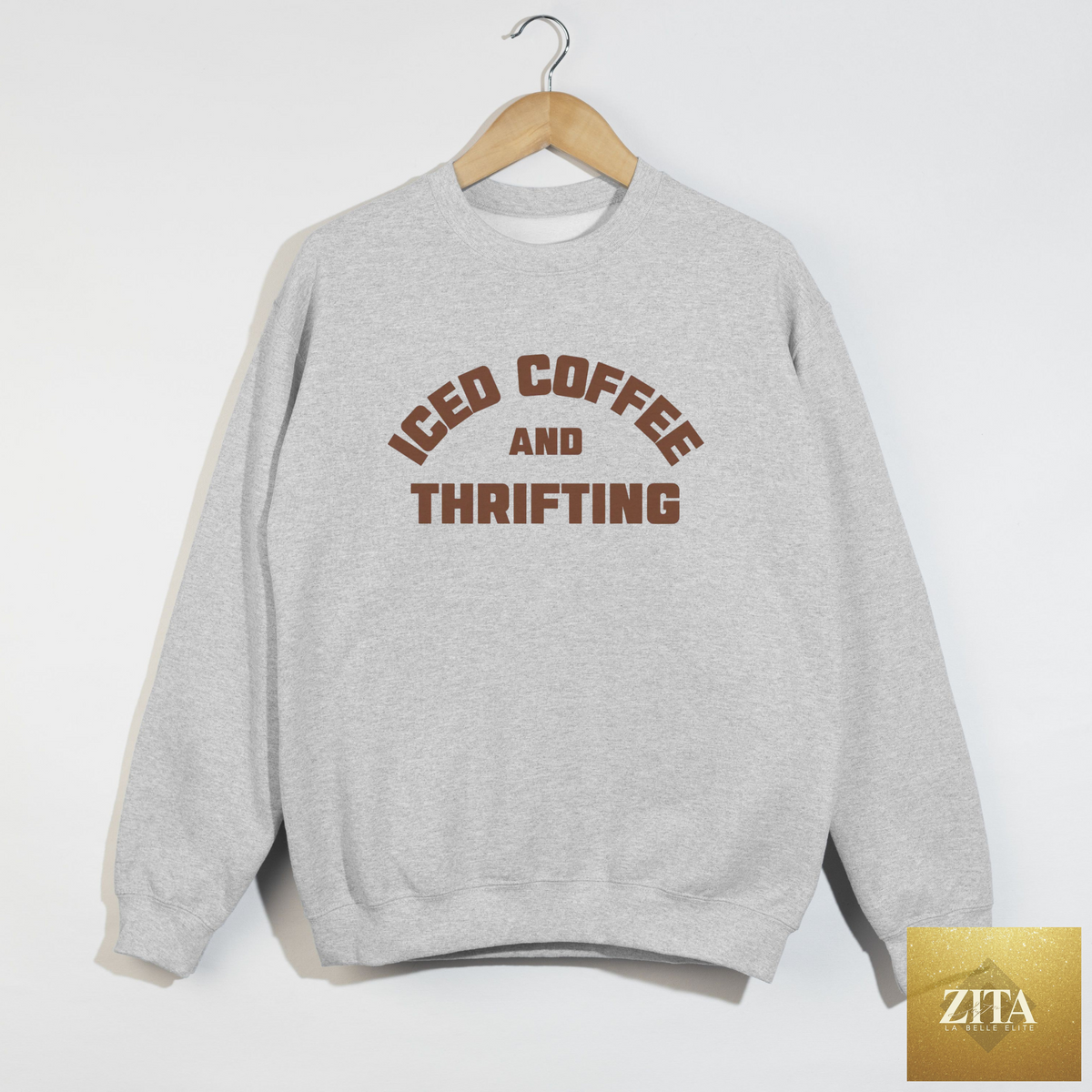 Ash grey crewneck sweatshirt featuring "Iced Coffee & Thrifting" graphic by Hey Jude Graphic Tees, casual neutral thrift girl style.