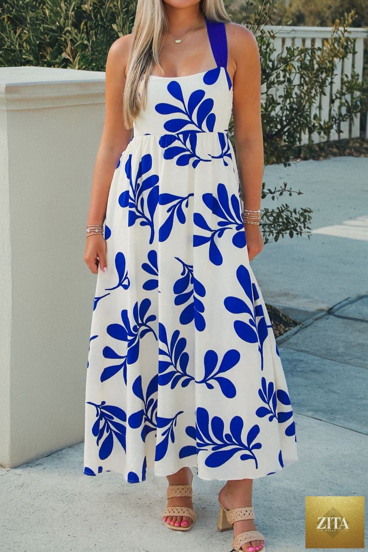 Blue floral print maxi dress with crisscross tie back and sleeveless design from Wild and Free Boutique.