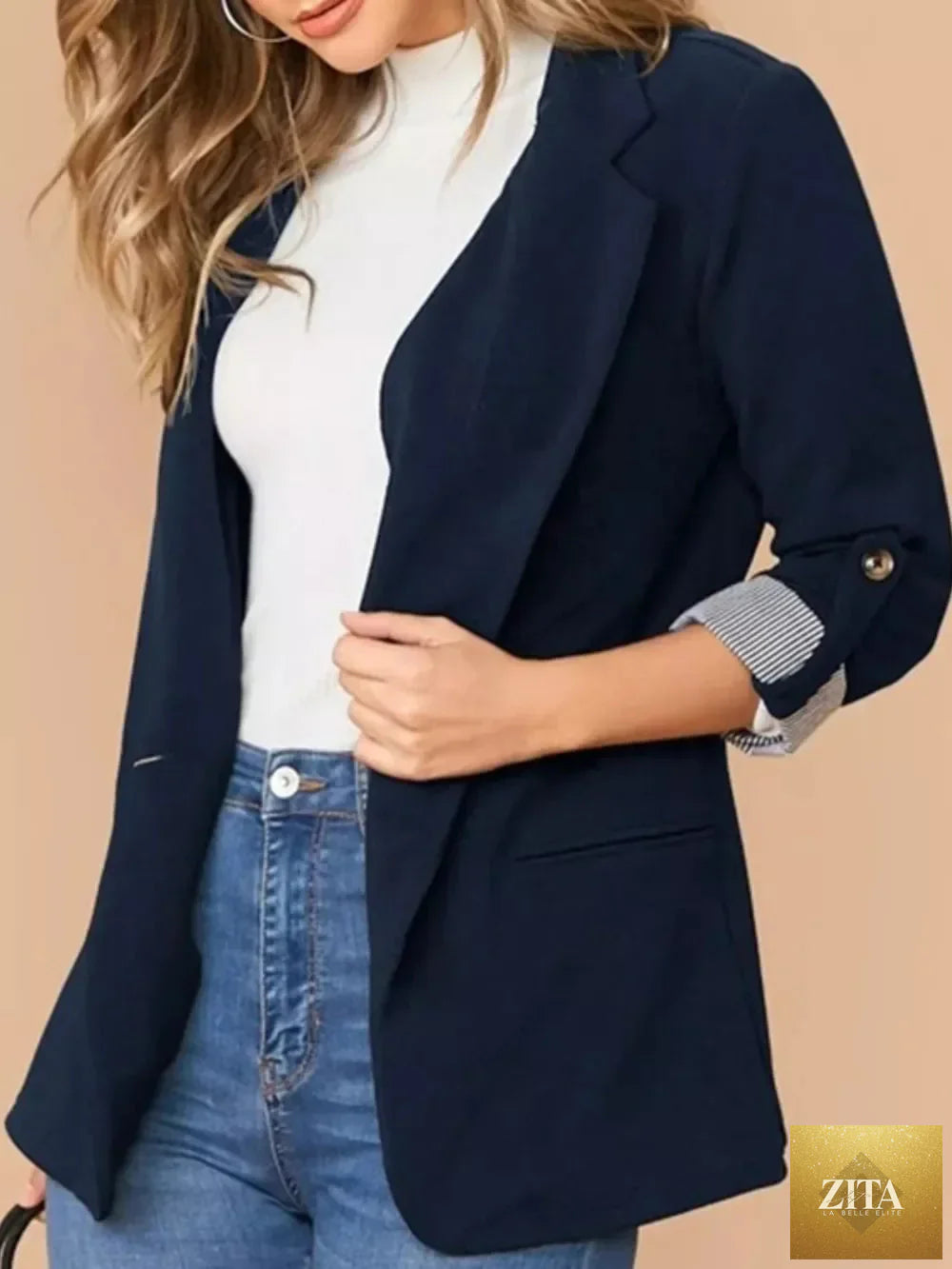 SITRA lapel collar blazer with roll-tab sleeves, tailored fit, and classic design in neutral fabric, suitable for professional or casual wear.