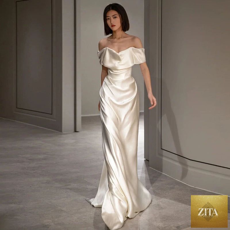 Elegant French white off-shoulder wedding dress for women, showcasing light, flowing fabric and romantic design.