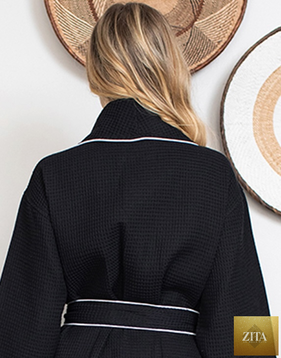 Back view of Lotus Linen women's plush bathrobe in small black with piping, featuring a waffle texture and soft, cozy fabric.