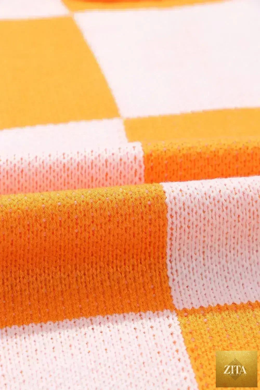 Orange checkered Femstylo sweater with bishop sleeves, featuring a stylish and cozy design perfect for casual wear.