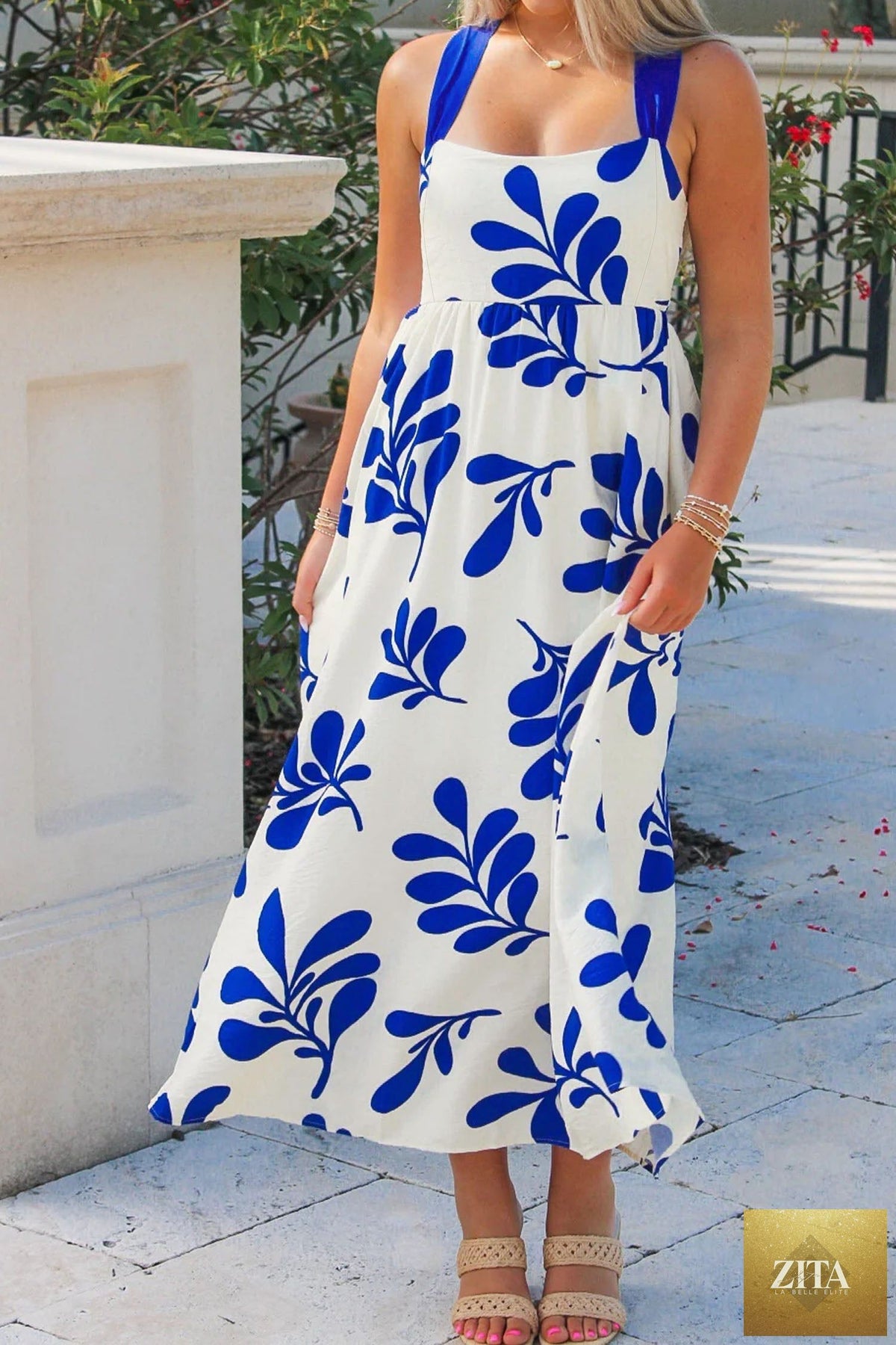 Blue floral print sleeveless maxi dress with crisscross tie back from Wild and Free Boutique, featuring a flowy design.