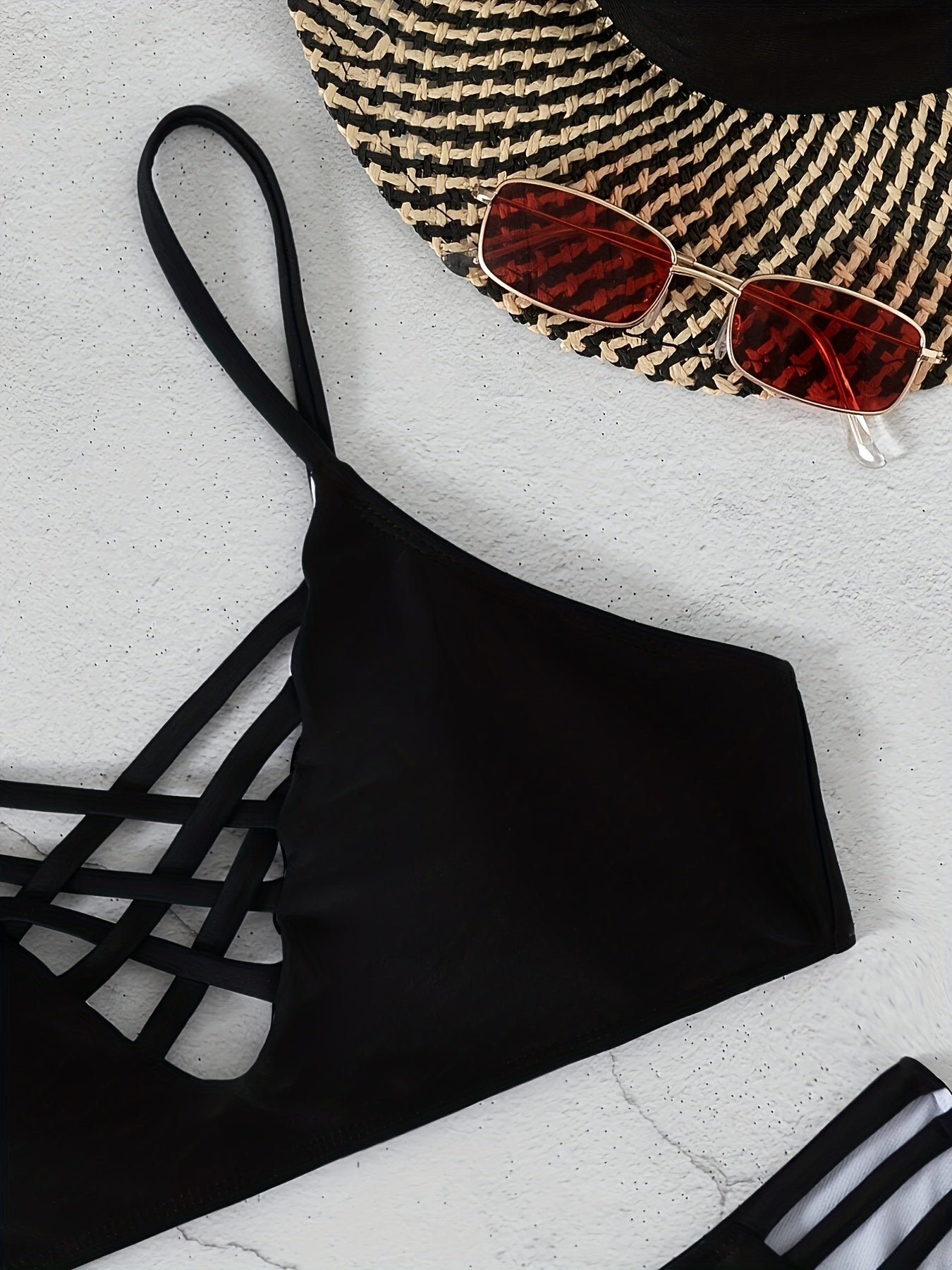 Black Stevvex Noir Allure criss cross bikini set with high waist, hollow out design, buckle detail, adjustable straps, and medium stretch nylon.