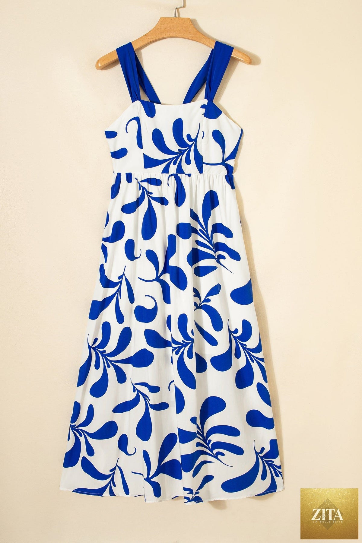 Blue floral print maxi dress with crisscross tie back and sleeveless design from Wild and Free Boutique.