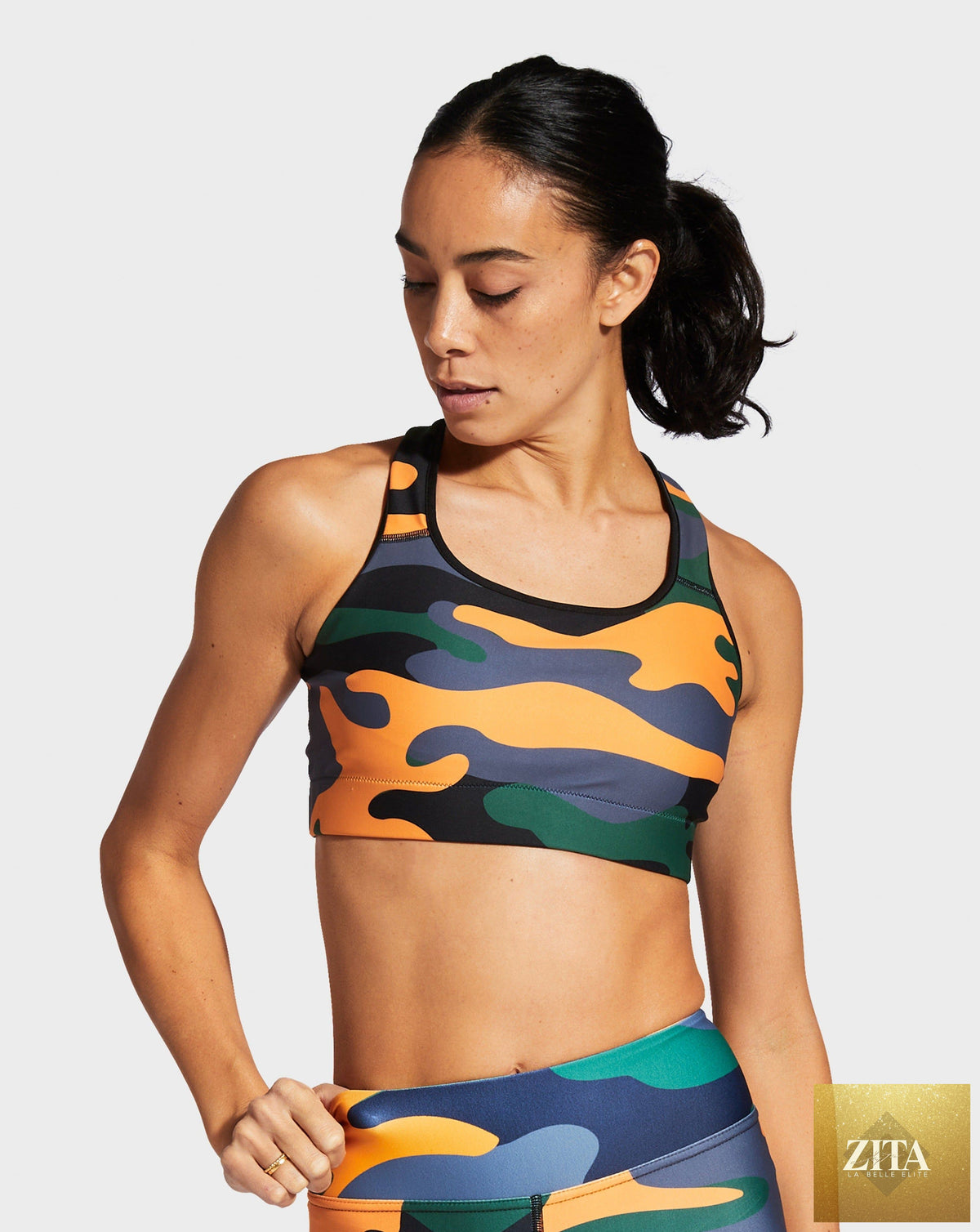 RUFFHAUS NYC camo orange sports bra with black straps, designed for activewear and athletic support.
