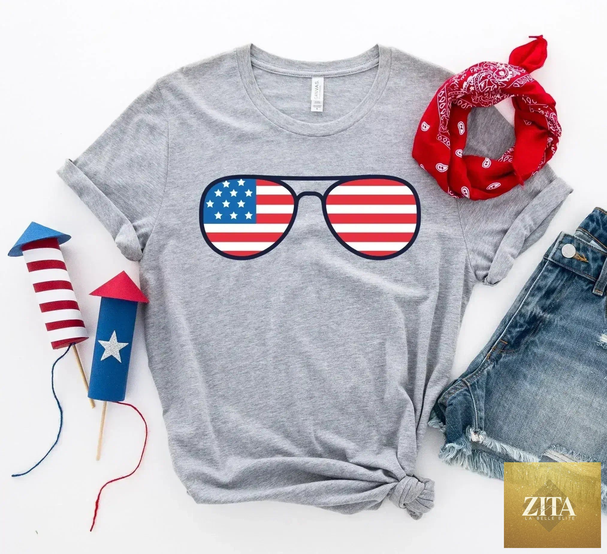 Femstylo American Flag sunglasses T-shirt made of premium cotton, featuring a bold American flag design on a casual Bella Canvas tee.