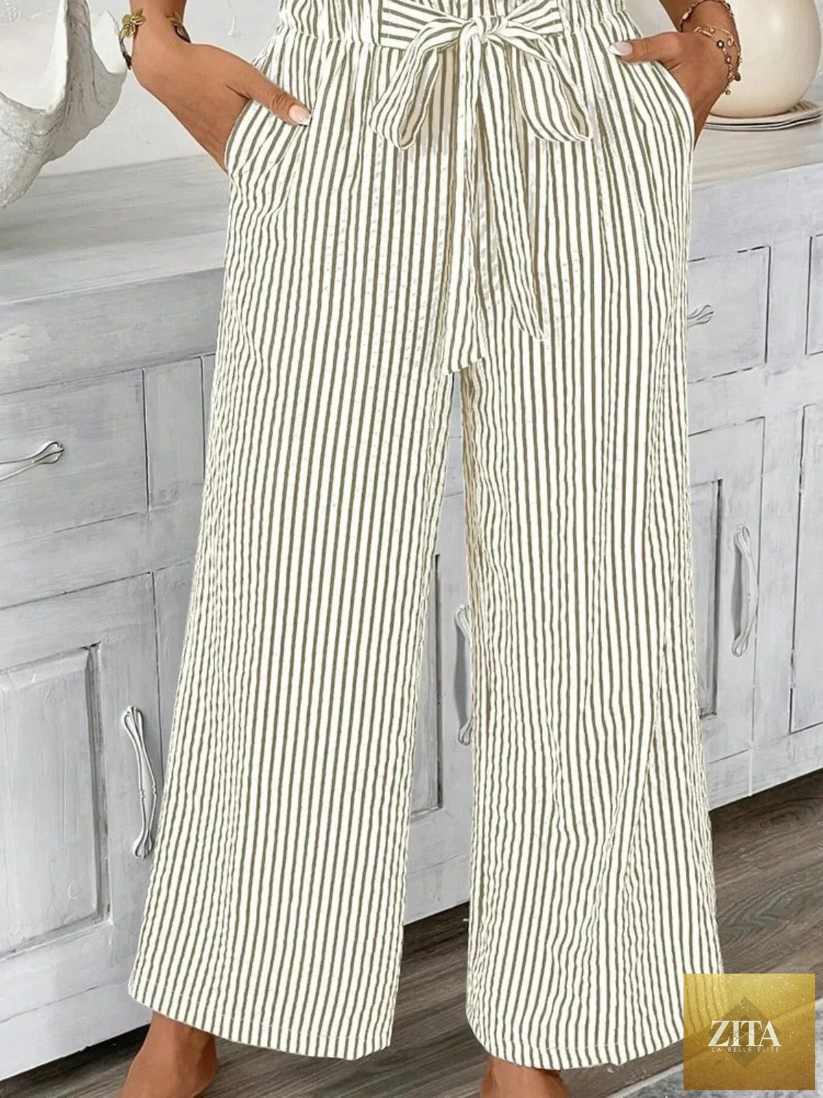 Plus size striped wide leg paper bag pants by SITRA featuring a high waist and relaxed fit, styled with casual top.