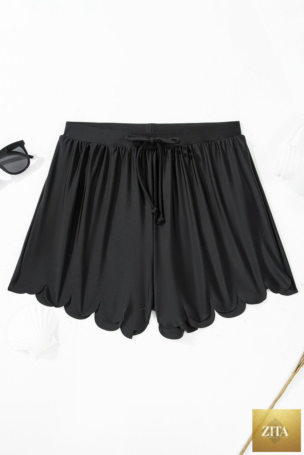 Black scallop trim drawstring beach shorts from Wild and Free Boutique, showing the stylish scalloped hem and comfortable fit.