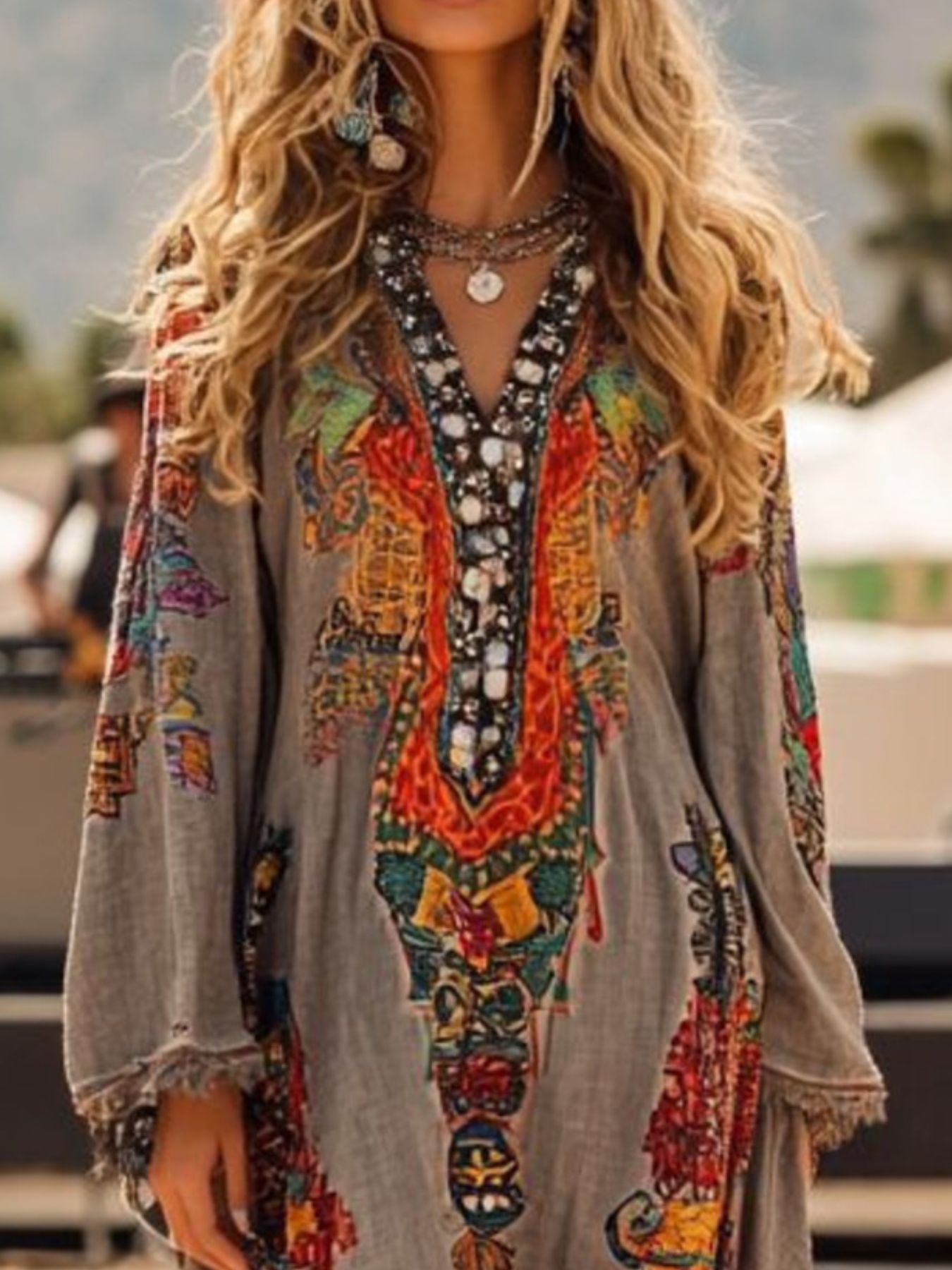 Long sleeve dress with fringe hem and notched neckline by Shopiebay, showcased in a stylish, flowing design.