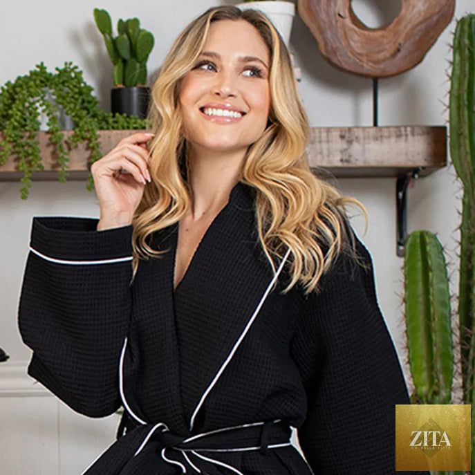 Front view of Lotus Linen women's knee-length black waffle robe with piping, showcasing its cozy, stylish design.