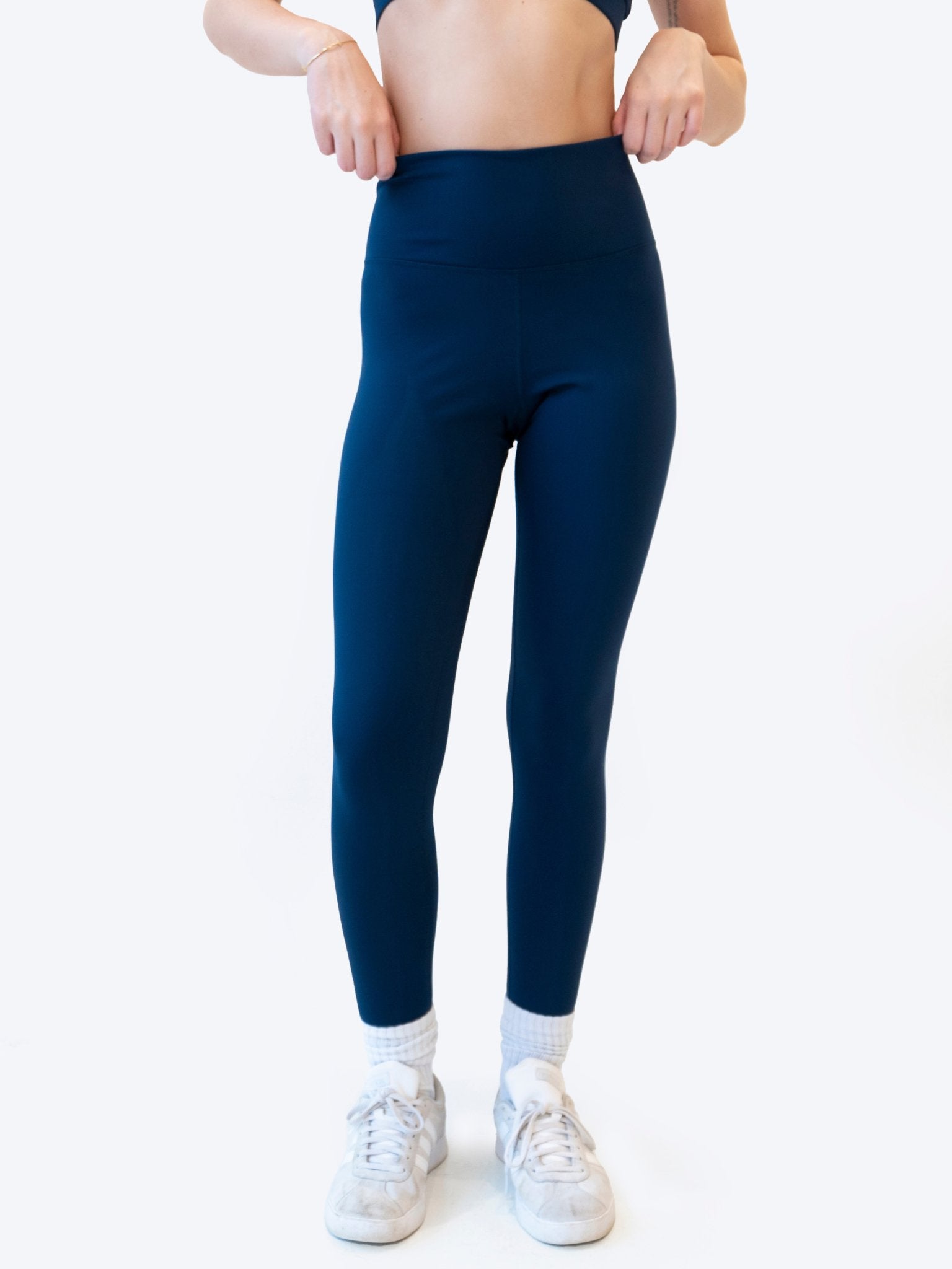 Reprise Activewear Fusion Leggings showing a close-up of black and colorful patterned athletic leggings on a model.