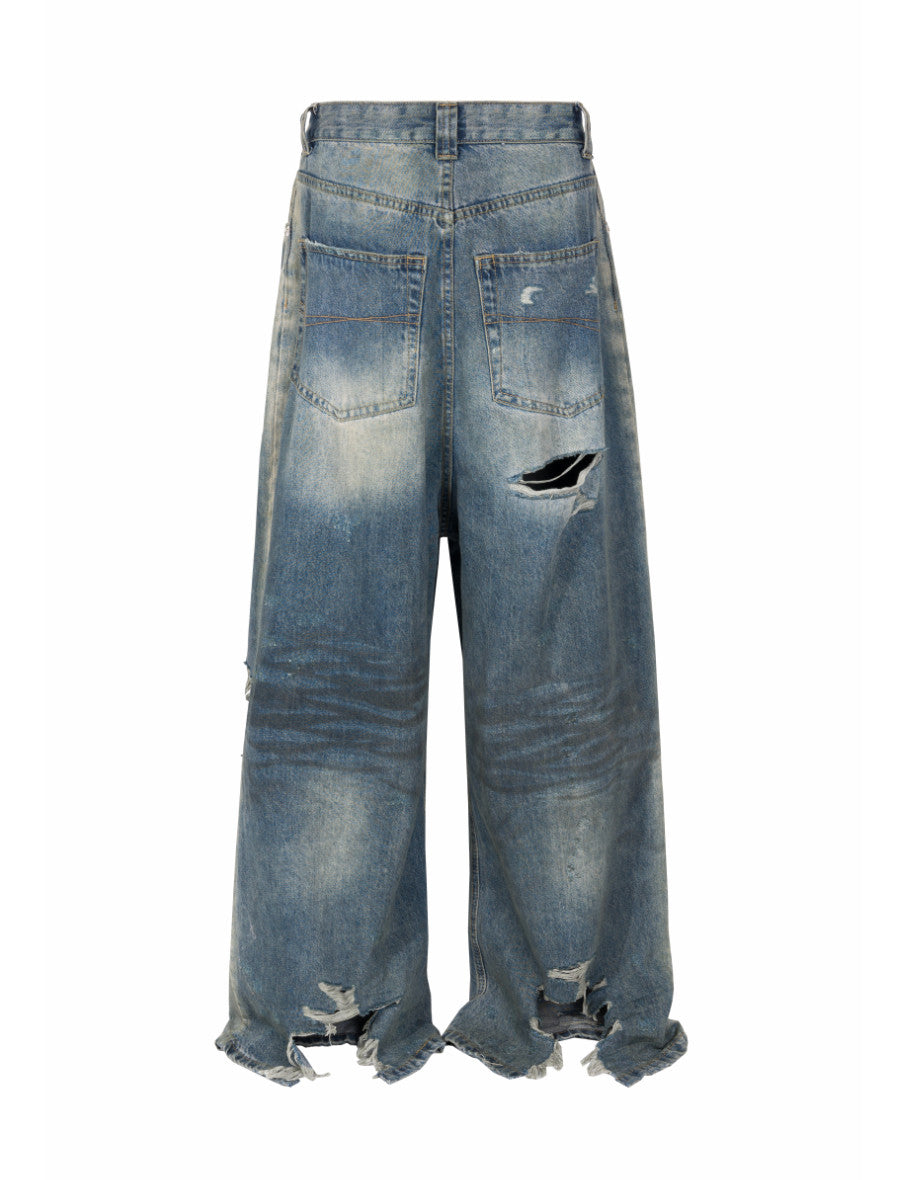 Distressed wide-leg denim jeans by UNDEVELOPED featuring ripped details and a relaxed fit, shown in a natural pose.