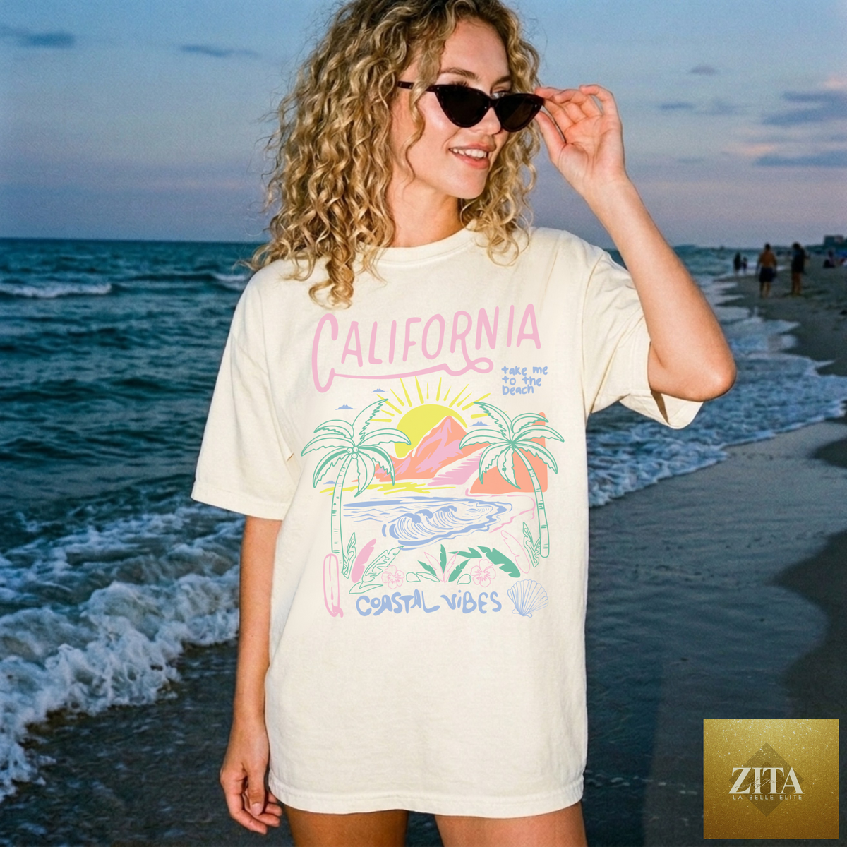 Ivory California Coastal Vibes graphic tee featuring a beach sunset scene, by Hey Jude Graphic Tees.