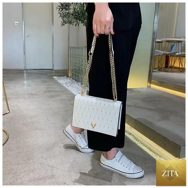 Elegant Stevvex genuine leather crossbody bag for women, featuring a sleek design, designer chain strap, and modern luxury style.