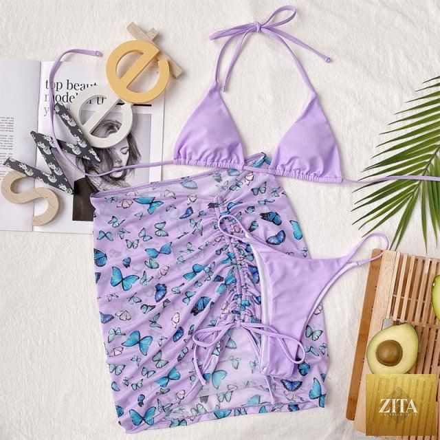 Stevvex 3-piece women's bikini set with high-cut swimsuit, halter top, wrap skirt, lace-up details, backless design and string accents.