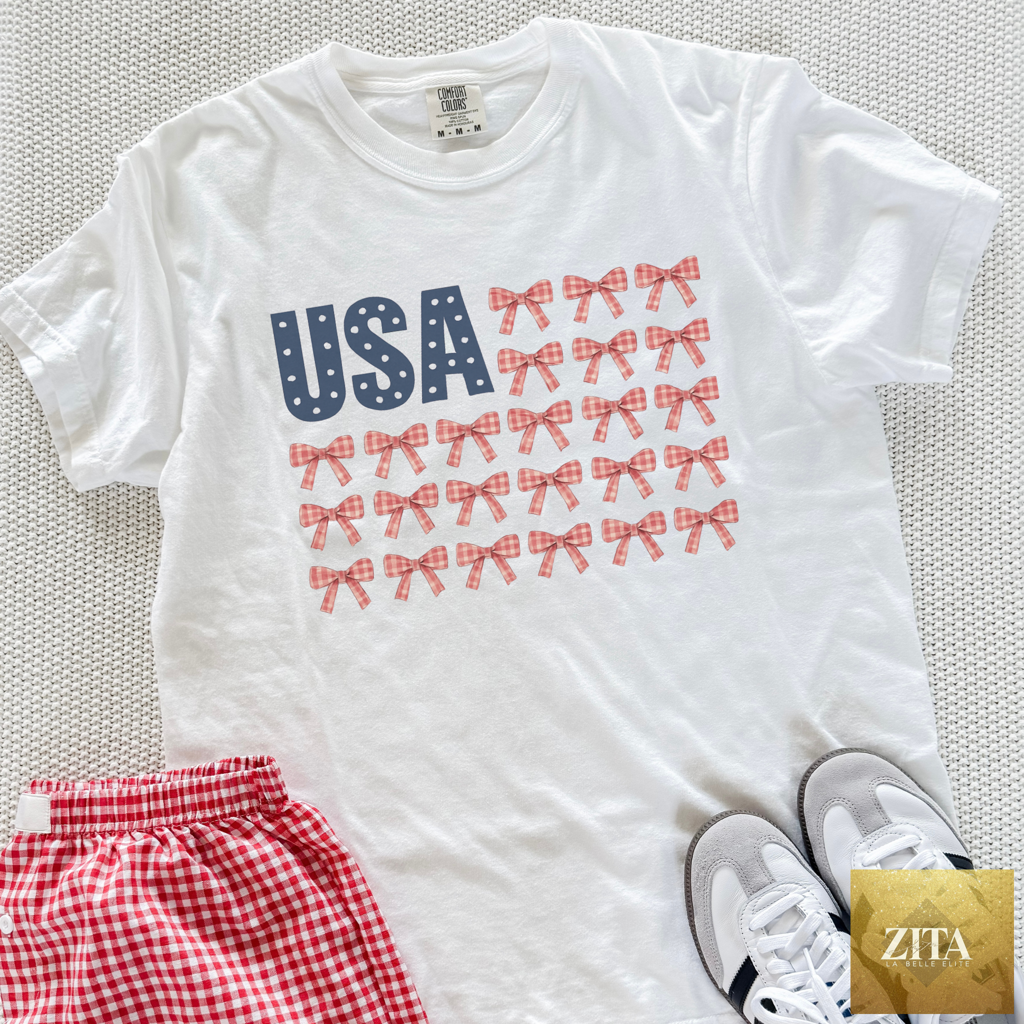 Hey Jude Graphic Tees USA Bow Flag graphic t-shirt featuring patriotic gingham bows on a white background.