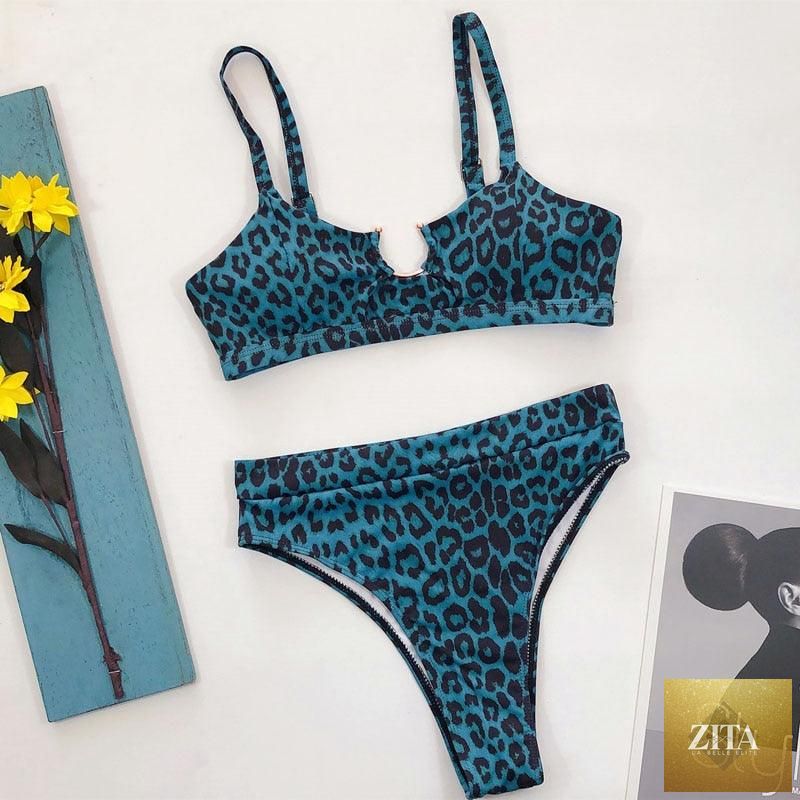 Women wearing a high-waist bikini with metal rings, cross bands, and cutout details, featuring a tie-back design in a two-piece swimsuit.
