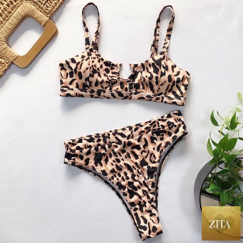 Women wearing high-waist bikini swimsuit with metal ring accents, cross bandage design, cutout details, and tie-back style.