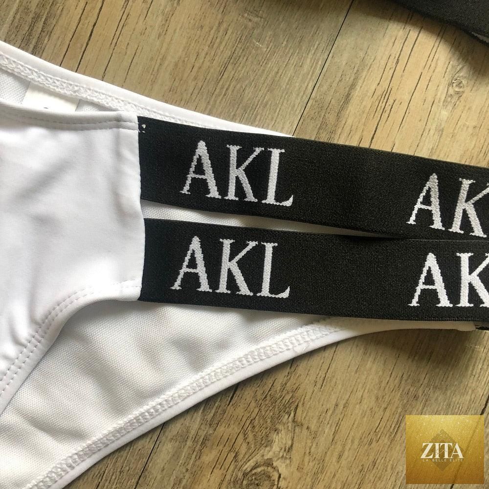 Women wearing luxury black and white Stevvex push-up bikini with lace-up design, halter style, letter print, and bandage fit for summer.