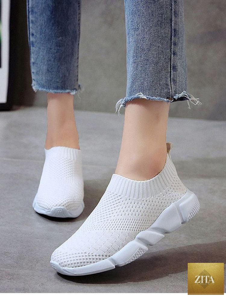 Women Stevvex white slip-on sneakers with breathable mesh material, lightweight vulcanize shoes ideal for casual walking and running.