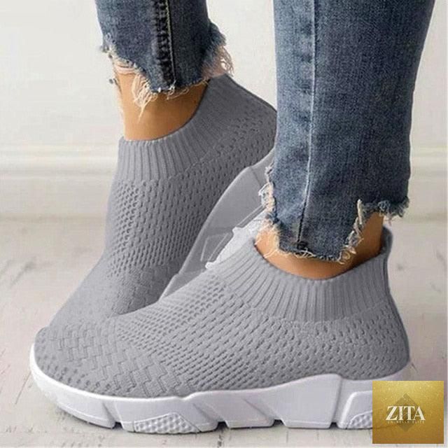 Women Stevvex slip-on white sneakers with breathable mesh, lightweight vulcanized design, ideal for walking, casual wear, and workouts.