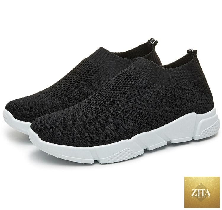 Women Stevvex slip-on white sneakers with breathable mesh, lightweight vulcanize design, perfect for casual walking and light workouts.