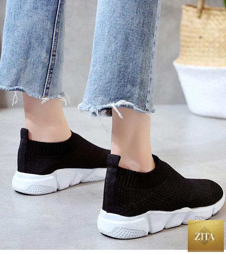 Women Stevvex slip-on white sneakers with breathable mesh, lightweight vulcanized sole, casual and walking-friendly design.