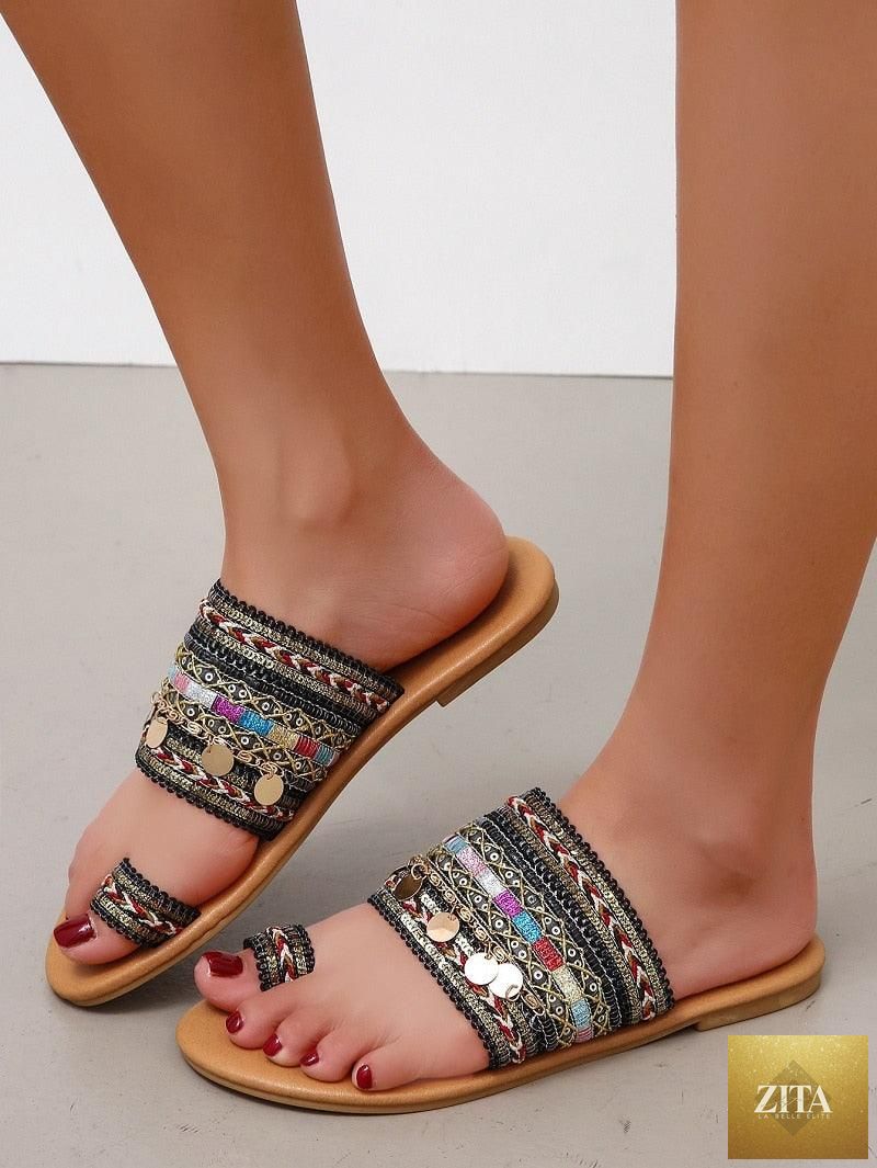 Women wearing shiny leather flat sandals with open toes and strappy design, ideal for summer beach casual wear.