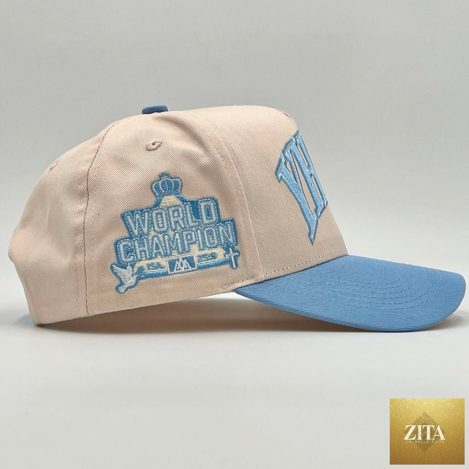 Cream and baby blue structured snapback hat with "YHWH" embroidered design by Malta Apparel, featuring a classic adjustable fit.