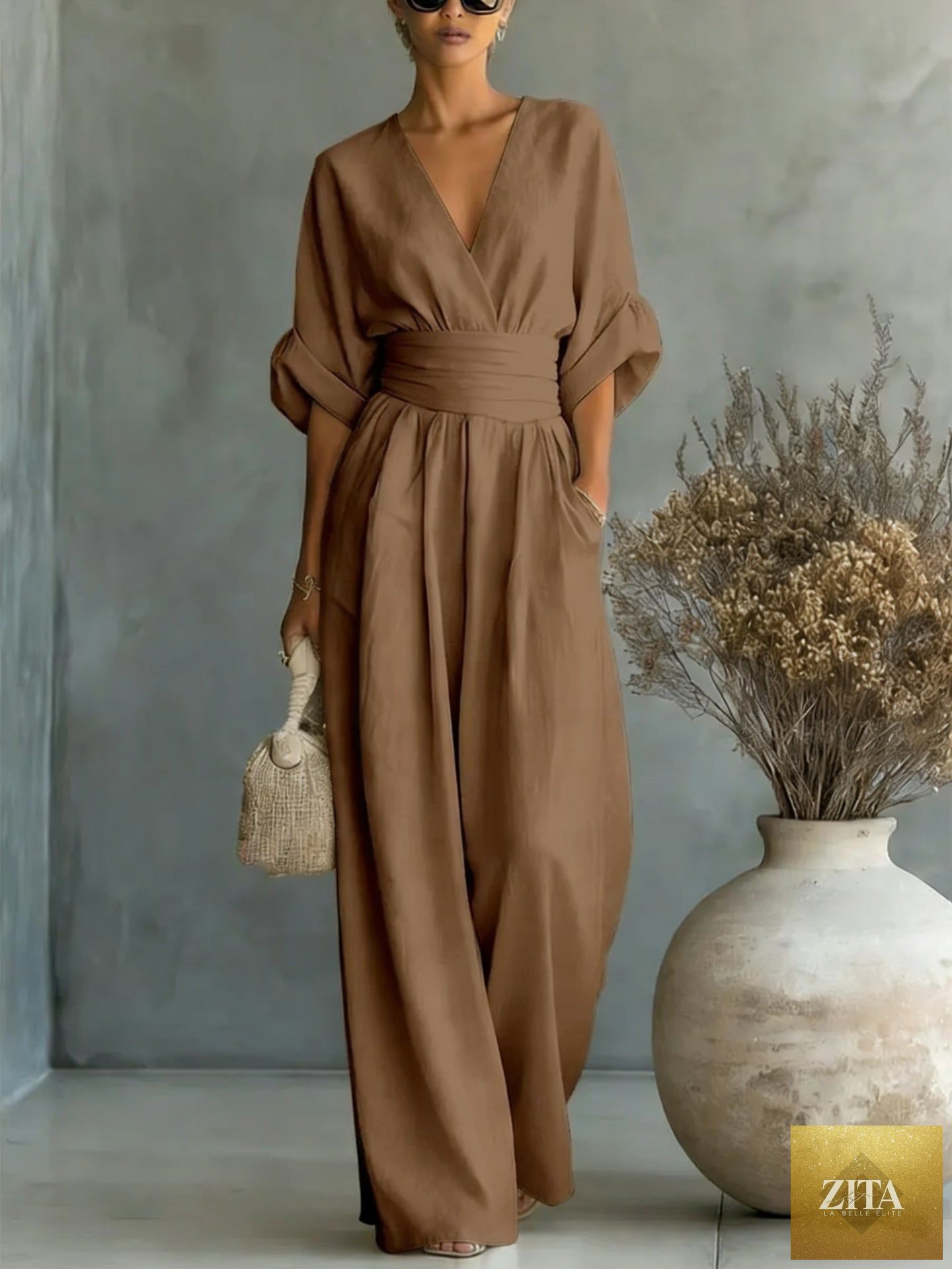 Women's V-neck wide-leg jumpsuit by MERIDGE featuring high waist, pleated design, and elegant style, shown in a full-length view.
