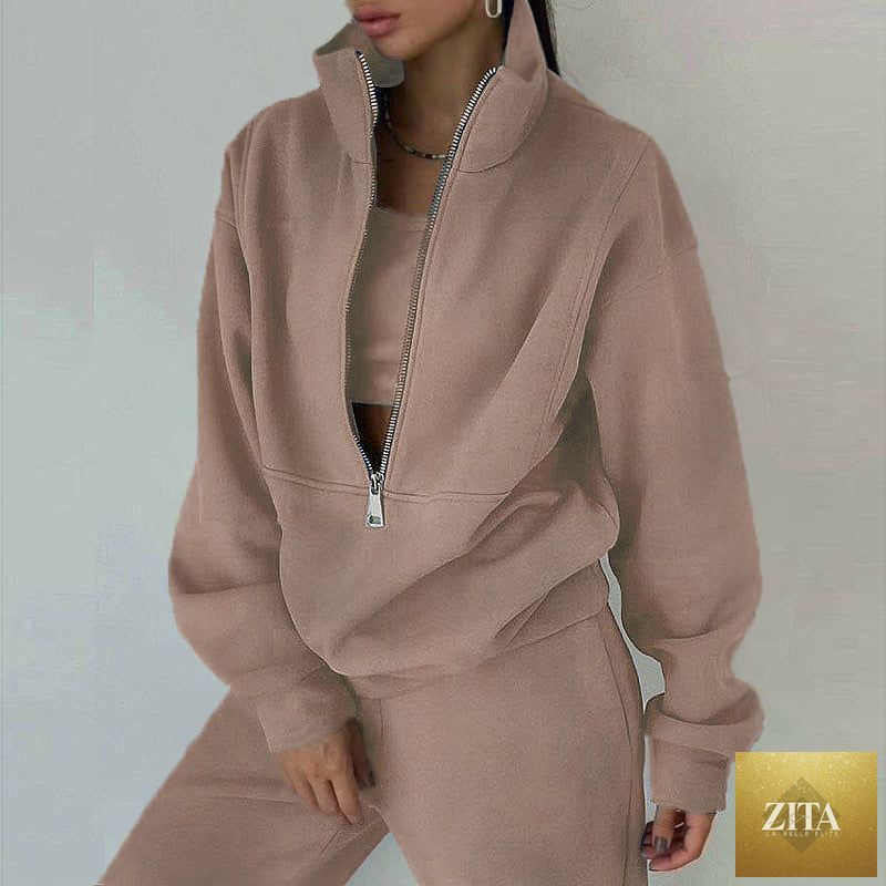 Women's fleece two-piece set by MERIDGE with a full-zip cropped sweatshirt and wide-leg pants, shown in a cozy indoor setting.