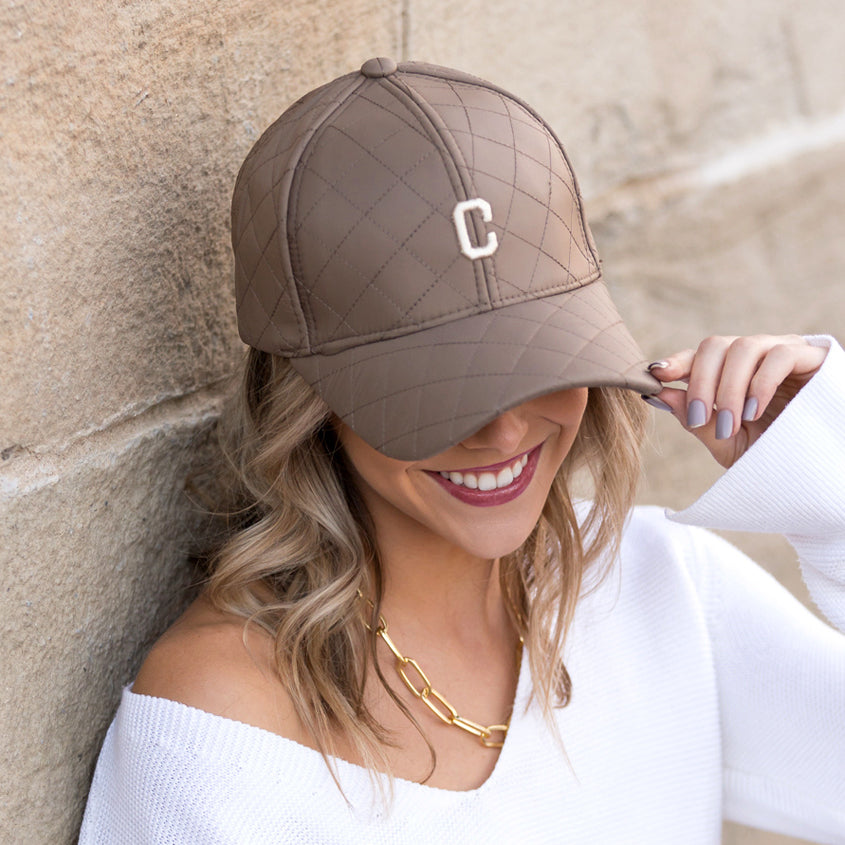 Aili's Corner quilted puffer baseball cap in black with a rounded brim and quilted padding, stylish and warm headwear.