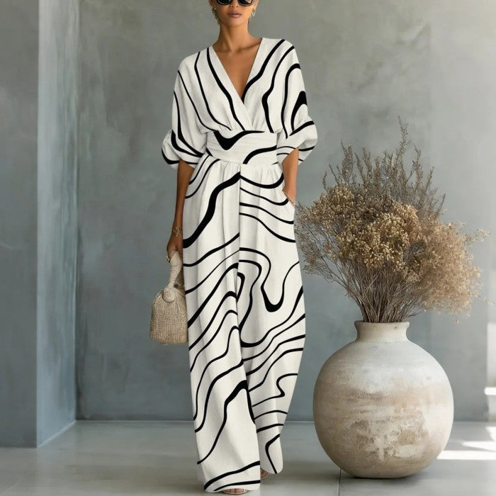 Women's waist-cinched V-neck printed wide-leg jumpsuit by FitiqueFit, featuring a casual style with a flattering waist and flowing legs.