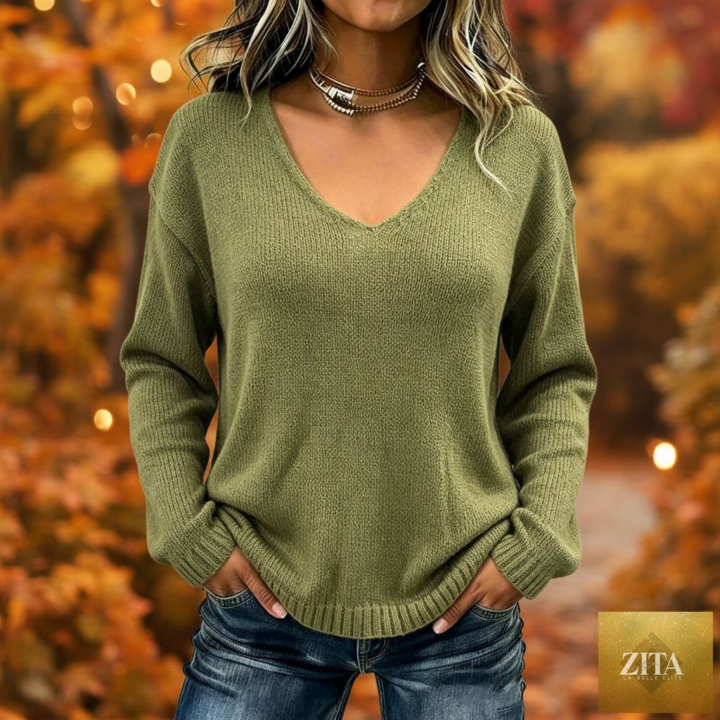 Women's relaxed FitiqueFit V-neck drop-shoulder sweater with a cozy knit texture and casual fit, displayed on a hanger.